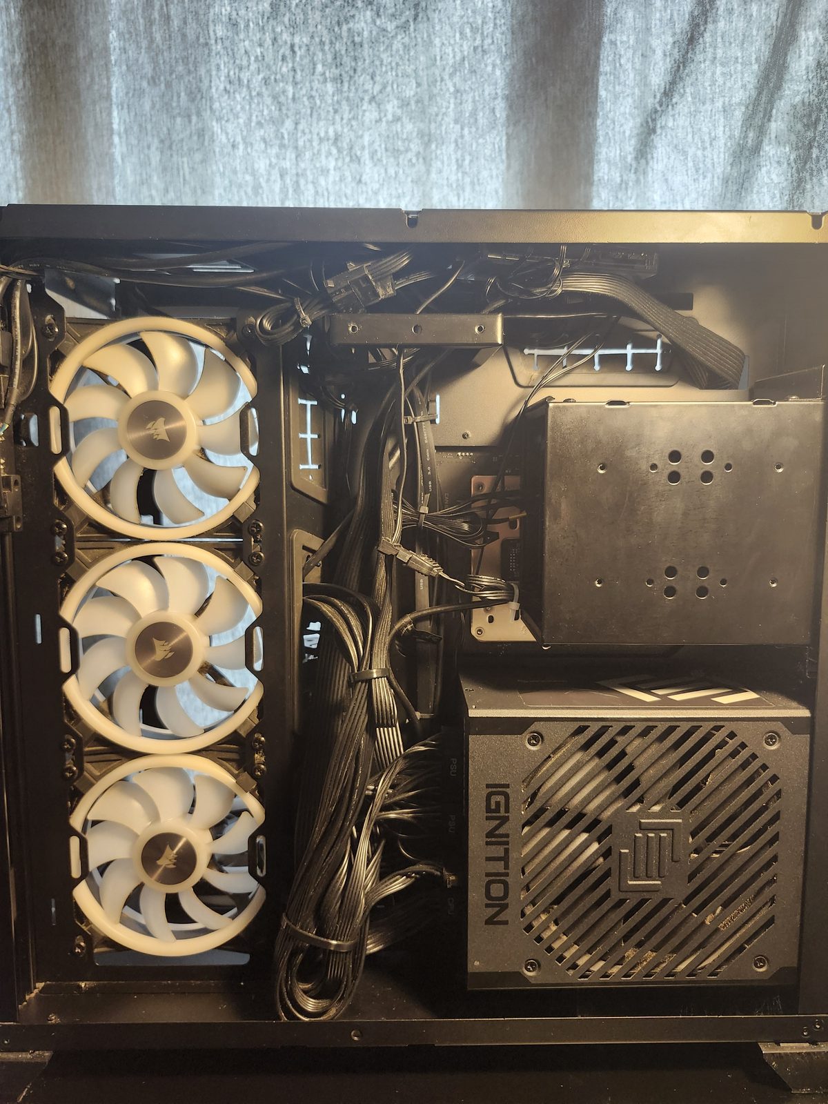 Back chamber with the cover off. Cables are bundled down the middle, three white Corsair fans are on the left, and the Ignition power supply is at the bottom.